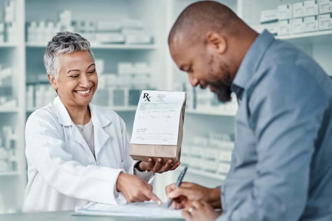 man picking up prescription at pharmacy